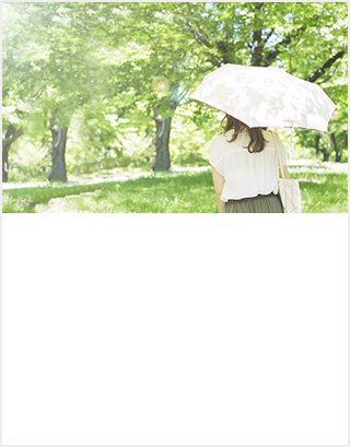 陽が差し込む森林の中で日傘を差しながら歩く女性のイメージ図